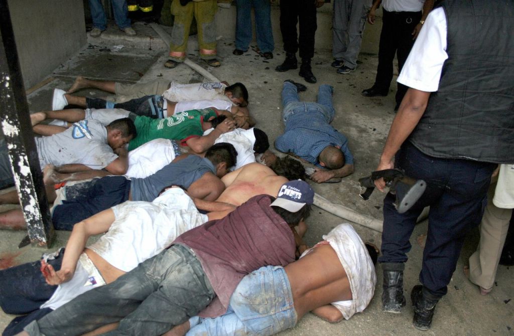 Cancun, MEXICO:  Policemen guard a group of inmates during a riot at the municipal prison of Cancun, in the Mexican state of Quintana Roo, on December 8th, 2006. The revolt erupted Friday when the prisoners' leader, Marco Adelaido Gallegos, known as "The Godfather" and some 50 other inmates, were transferred to another facility. Two prisoners were killed, dozens injured and about 100 managed to escape during the first moments of confusion.   AFP PHOTO/Marte REBOLLAR  (Photo credit should read Marte REBOLLAR/AFP/Getty Images)